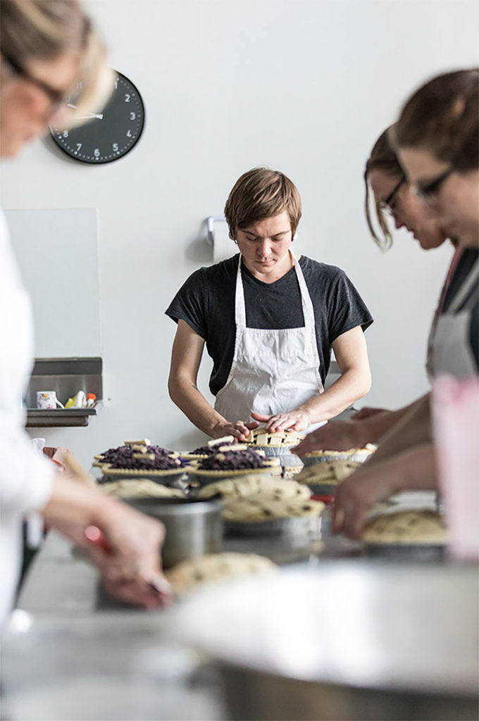 Creative, authentic portrait of a young man making a pie in a baking class. Photographed by Greta Rybus.