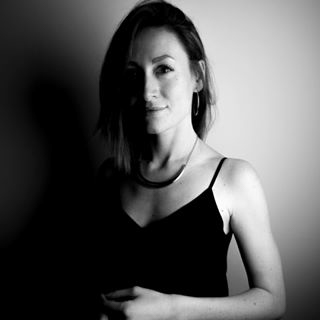 Black and white portrait photograph of multidisciplinary graphic illustrator and designer Lucia Walter. Walter is wearing a black top with a necklace.