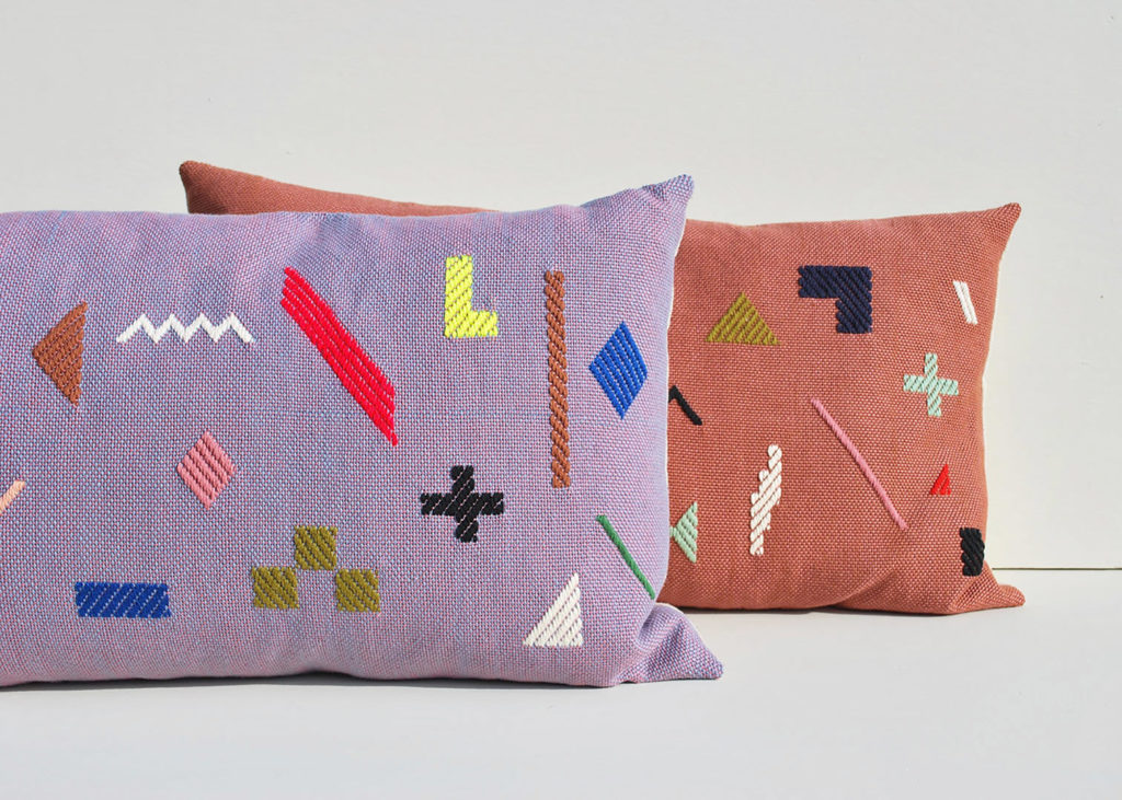 Textile artist, Sarah Sullivan, created these eclectic lumbar throw pillows with handstitched, minimal graphic shapes.