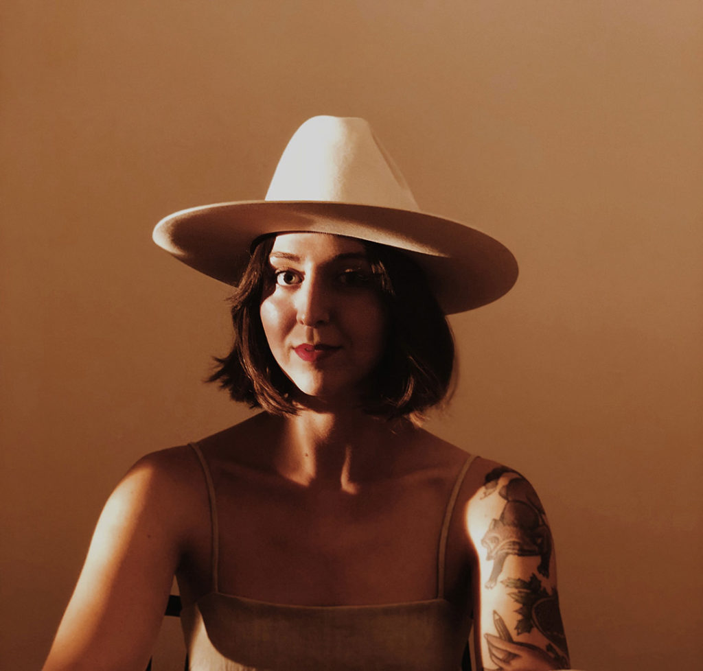 A soft-lit, warm portrait of Whitney Anderson, inspirational graphic designer and illustrator.