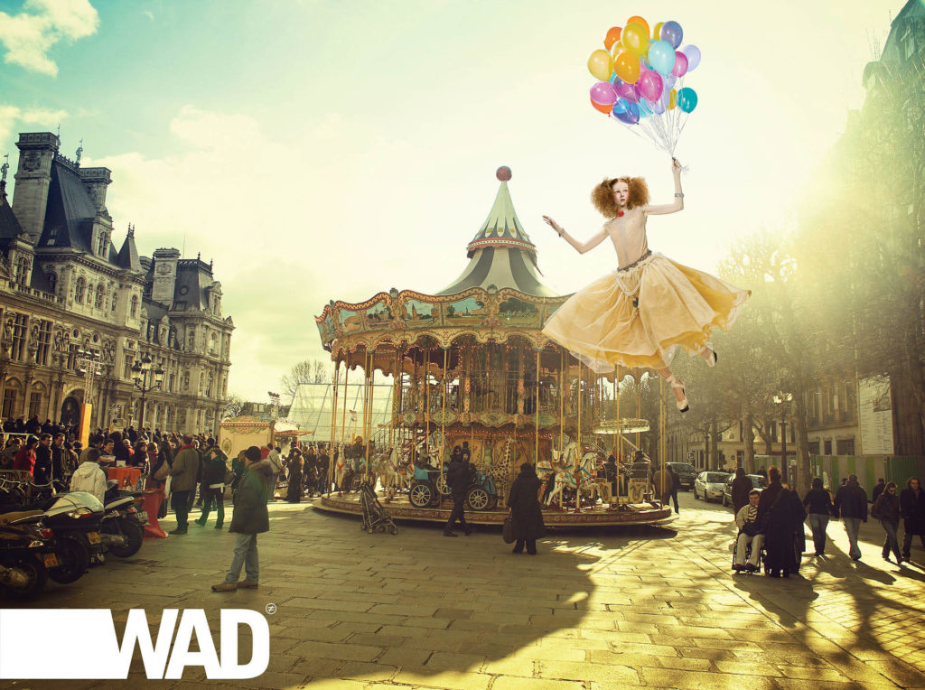 Surreal photo composition of a girl in a dress floating by a carousel. Judy Rush worked with The Wade Brothers on this campaign.